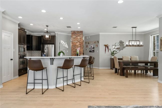 The chef' kitchen features a wraparound breakfast bar where household members can sit and chat with the cook. | Image 12