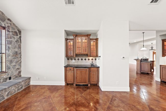 Bar featuring tasteful backsplash, dark tile patterned floors, baseboards, and a sink | Image 13