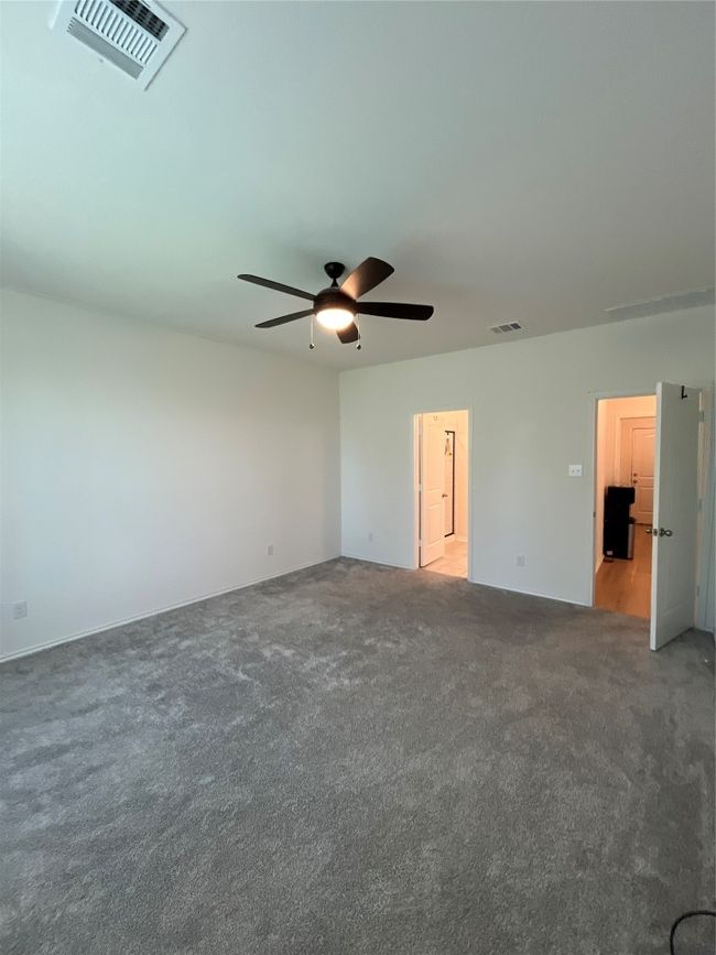 Carpeted empty room featuring ceiling fan and visible vents | Image 14