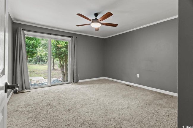 Carpeted spare room featuring crown molding, ceiling fan, and baseboards | Image 25