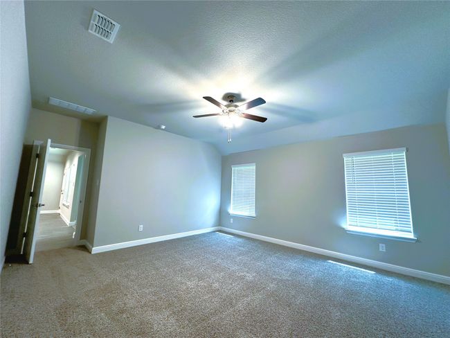 Carpeted empty room with ceiling fan and baseboards | Image 6