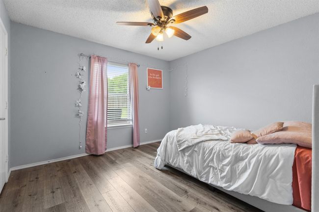 Bedroom with wood finished floors, baseboards, a textured ceiling, and a ceiling fan | Image 22
