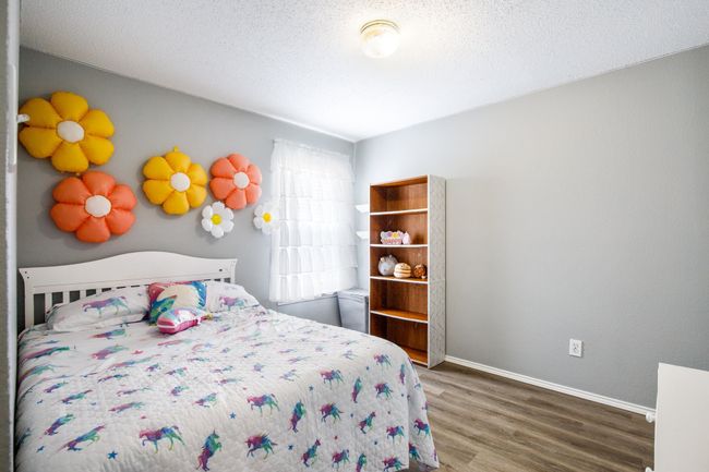 Bedroom with wood finished floors and a textured ceiling | Image 12