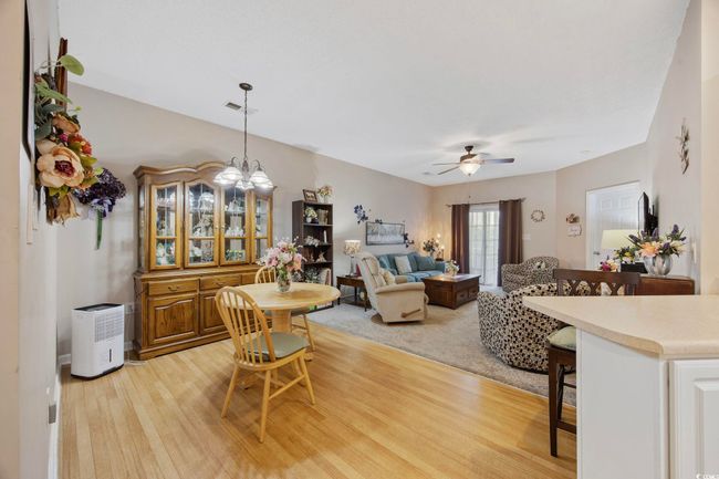 Dining room featuring ceiling fan, light wood-style floors, and a chandelier | Image 8
