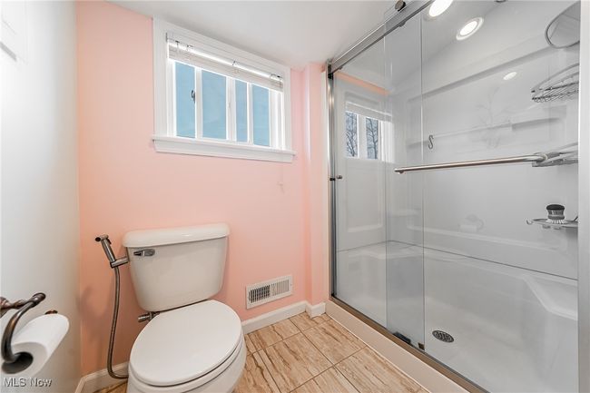 Full bath featuring a stall shower, baseboards, visible vents, and toilet | Image 29