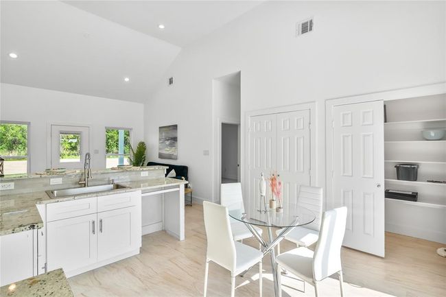 Modern kitchen with spacious pantry and convenient laundry room. | Image 12