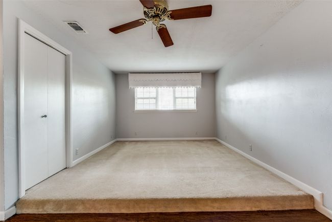 Unfurnished bedroom featuring carpet floors, baseboards, a ceiling fan, and a closet | Image 16