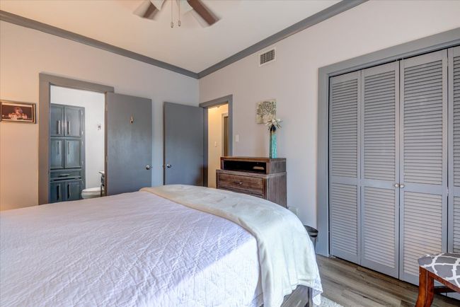 Bedroom featuring wood finished floors, ornamental molding, a closet, ceiling fan, and ensuite bath | Image 11