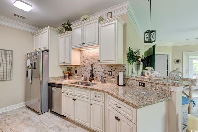 Kitchen featuring visible vents, ornamental molding, stainless steel appliances, and a sink | Image 6