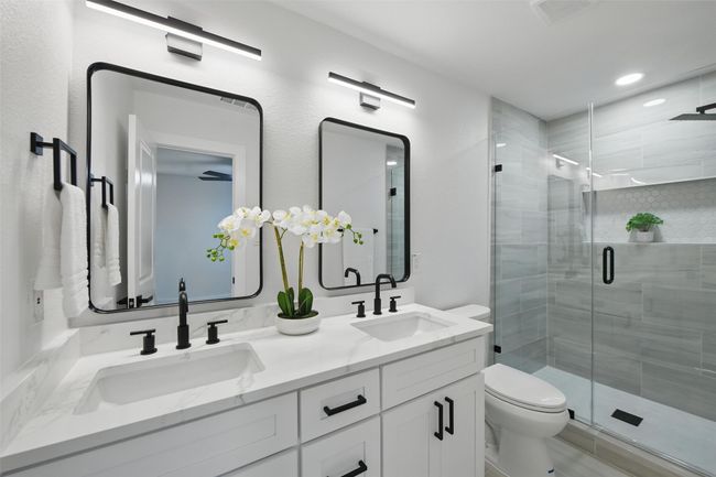 Bathroom featuring double vanity, toilet, a shower stall, and recessed lighting | Image 30