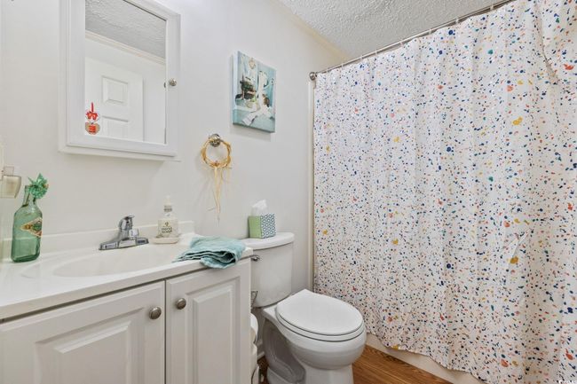 Bathroom with a textured ceiling, double vanity, crown molding, and tile patterned floors | Image 19