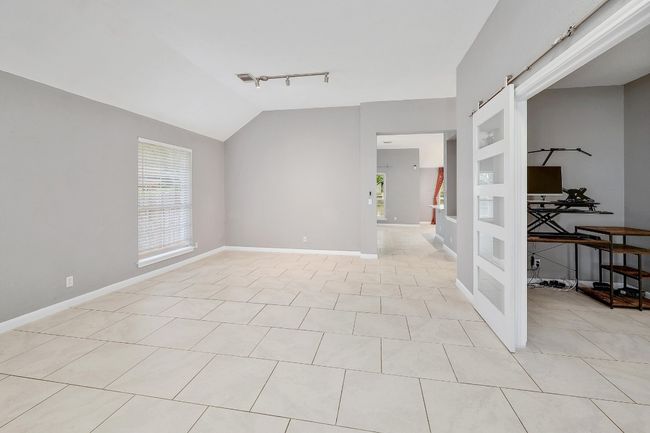 Unfurnished room with baseboards, track lighting, light tile patterned flooring, visible vents, and lofted ceiling | Image 18