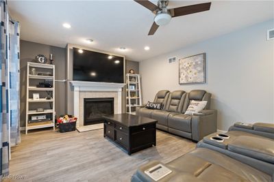 Living room with a tiled fireplace, light hardwood / wood-style floors, and ceiling fan | Image 3