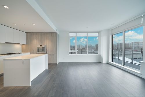 Unfurnished living room with dark wood-type flooring and a view of city | Card Image