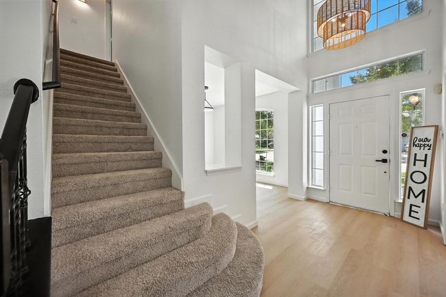 Foyer entrance featuring stairs, wood finished floors, and a high ceiling | Image 11