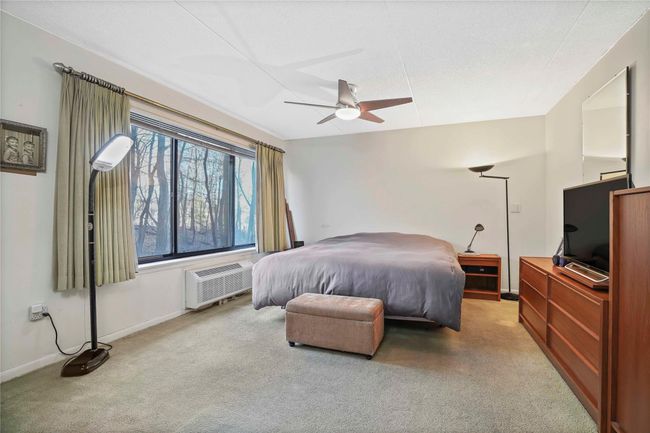 Carpeted bedroom with ceiling fan and a wall unit AC | Image 21