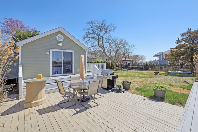 Deck featuring a grill, a yard, fence, and outdoor dining area | Image 41