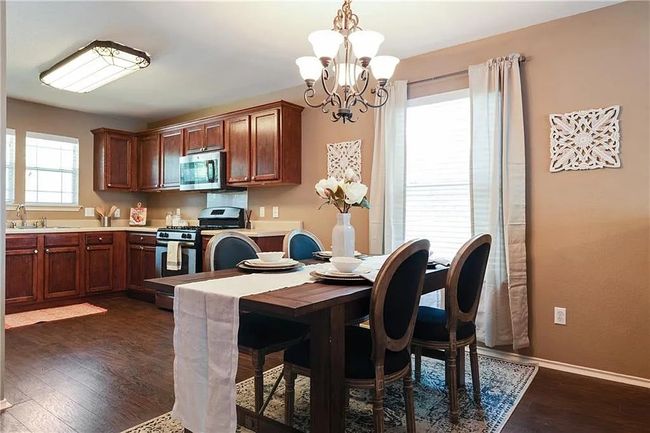 Dining area featuring a chandelier, dark wood finished floors, and baseboards | Image 7