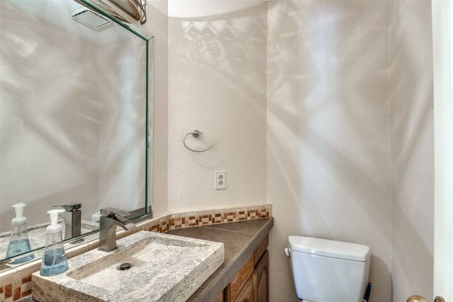 Bathroom featuring a textured wall and vanity | Image 14