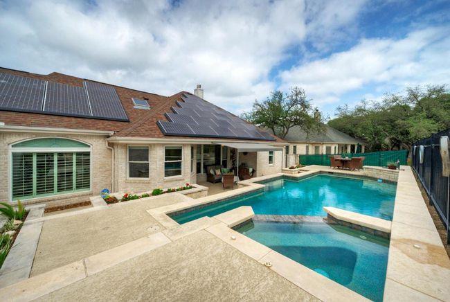 View of swimming pool with a patio, outdoor dining space, a fenced backyard, and a pool with connected hot tub | Image 34