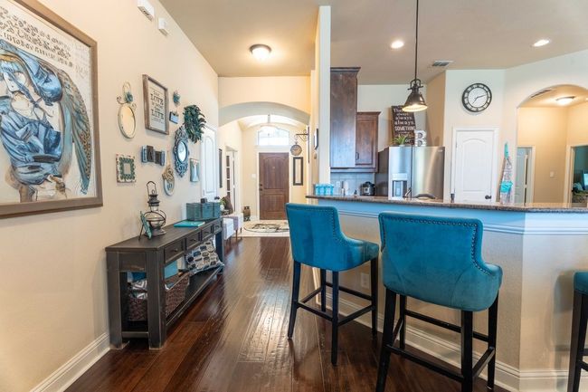 Kitchen featuring arched walkways, dark wood-style flooring, a kitchen bar, and pendant lighting | Image 8