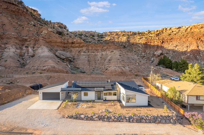 View of front facade with an attached garage, fence, solar panels, and concrete driveway | Image 54