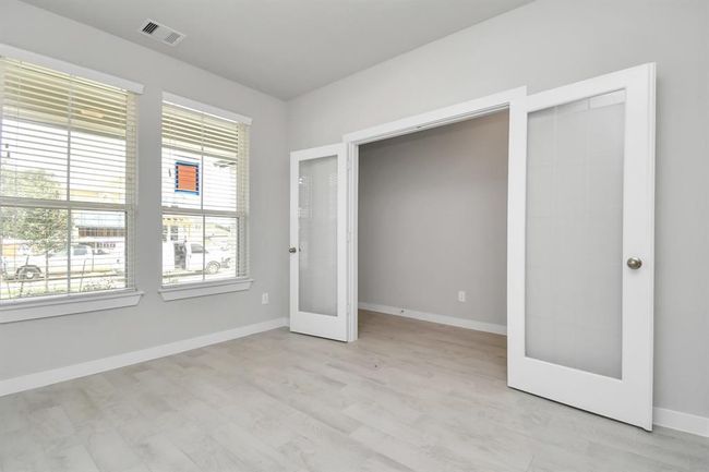 Quietly nestled in front of the home is the sophisticated home office. Featuring elegant flooring, custom paint and large window. | Image 9