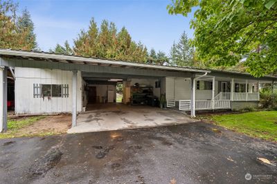 Check out this spacious 260-square-foot carport that’s ready to accommodate not one, but two cars! With an open doorway leading right into the backyard, it’s perfect for those who love to work outdoors or need easy access to their garden oasis. Plus, there's ample parking space, making it a breeze for you and your guests. This carport isn’t just a parking spot; it’s a multifunctional workspace and a seamless transition from car to outdoor paradise. | Image 3