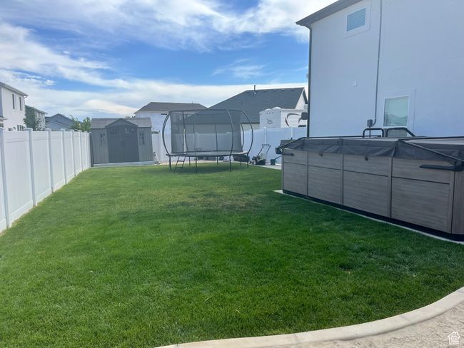 View of yard with a trampoline, a swimming pool, and a residential view | Image 32