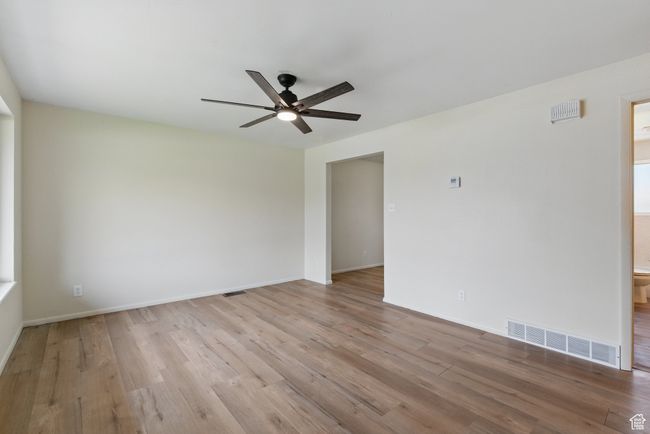 Empty room featuring light wood-type flooring, baseboards, visible vents, and ceiling fan | Image 6