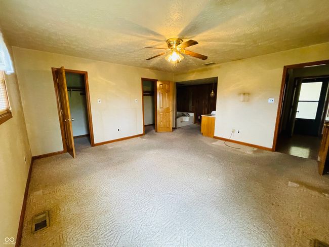 unfurnished living room featuring a ceiling fan, baseboards, a textured ceiling, and healthy amount of natural light | Image 21