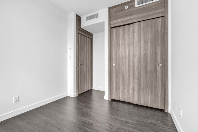 Unfurnished bedroom featuring a closet and dark wood-style floors | Image 15