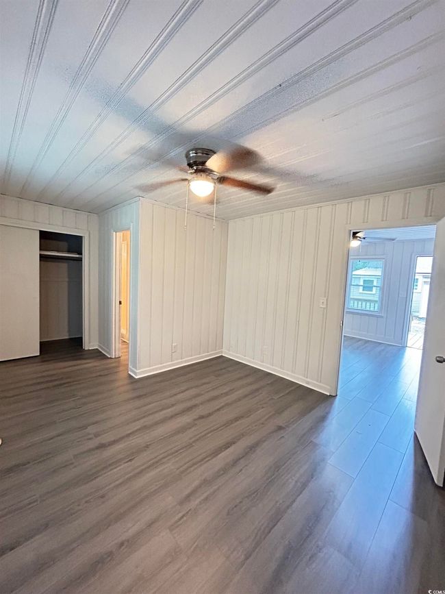 Unfurnished living room with a ceiling fan and dark wood finished floors | Image 6