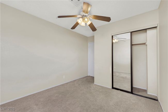 Unfurnished bedroom featuring a ceiling fan, visible vents, a closet, and light colored carpet | Image 34