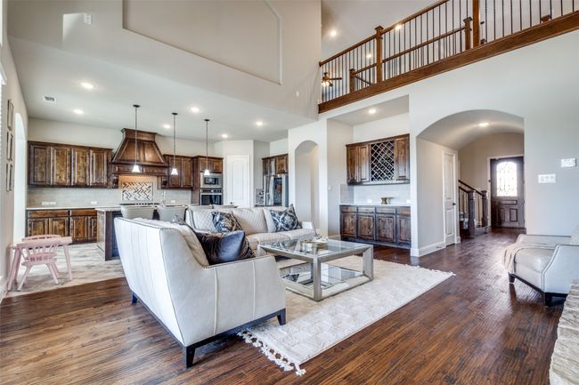 Living room featuring hardwood / wood-style flooring, bar area, and a high ceiling | Image 6