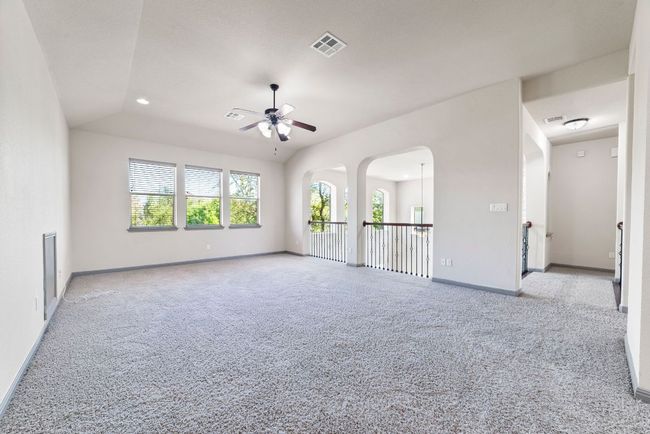 Empty room with a ceiling fan, light colored carpet, recessed lighting, and arched walkways | Image 32