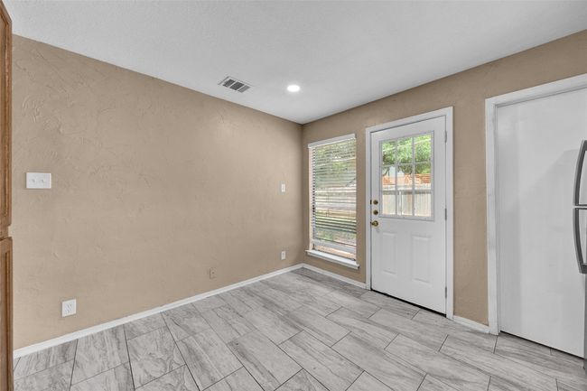 Doorway featuring baseboards, a textured wall, and visible vents | Image 6