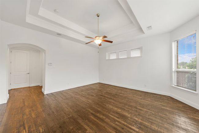 Spare room featuring a raised ceiling and dark wood-type flooring | Image 18