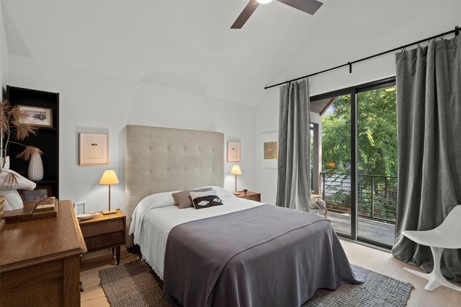 Bedroom with access to exterior, light wood finished floors, a ceiling fan, and high vaulted ceiling | Image 35