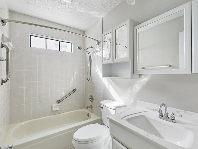 Full bathroom with shower / washtub combination, a textured ceiling, vanity, and toilet | Image 22
