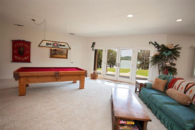 Living room featuring ceiling fan, a tiled fireplace, and light carpet | Image 14