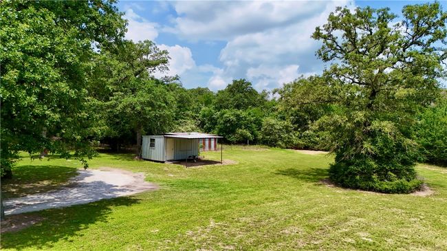 View of green lawn with a storage unit | Image 6