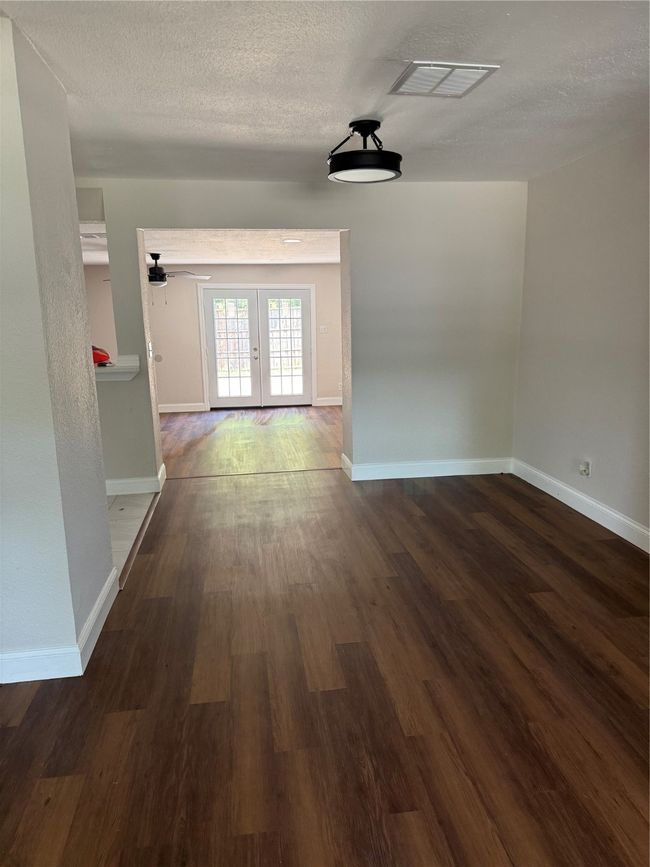 Corridor with french doors, dark wood-style flooring, and a textured ceiling | Image 6