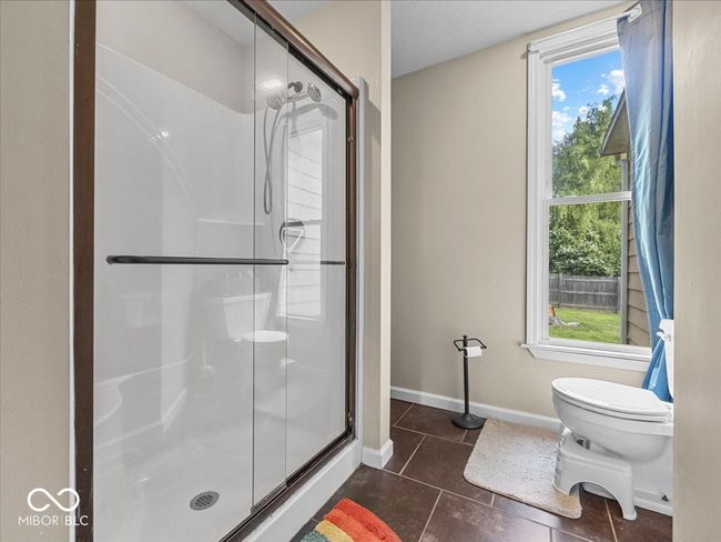 bathroom featuring a stall shower and tile patterned floors | Image 13