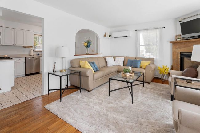 Living room featuring a healthy amount of sunlight, light hardwood / wood-style floors, and a wall mounted AC | Image 12