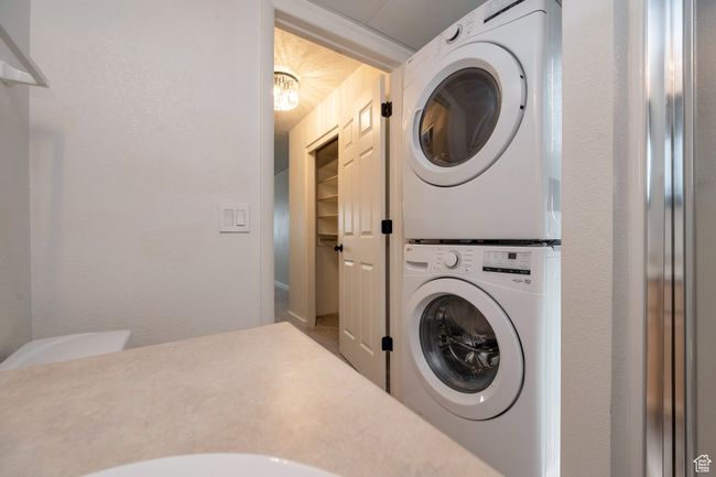 Washroom featuring stacked washing machine and dryer | Image 15