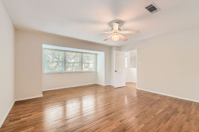Unfurnished room featuring baseboards, ceiling fan, visible vents, and wood finished floors | Image 16