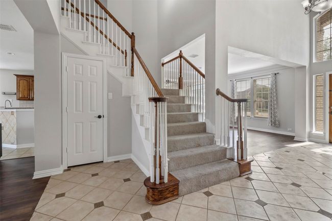 Entryway featuring a high ceiling, light tile patterned floors, and stairway | Image 21