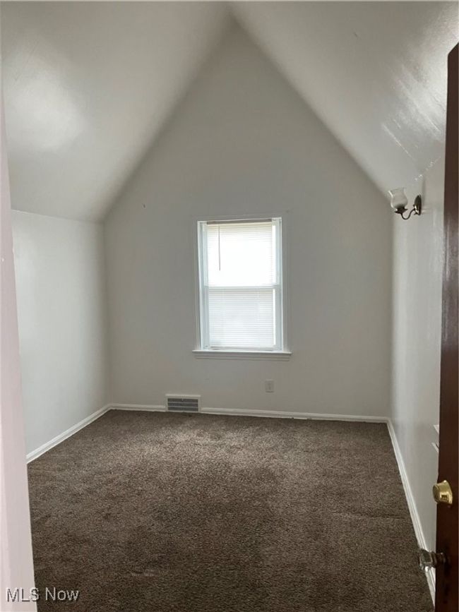 Additional living space featuring baseboards, visible vents, carpet flooring, and vaulted ceiling | Image 15