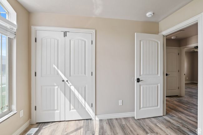 Unfurnished bedroom with multiple windows, wood finished floors, and baseboards | Image 17
